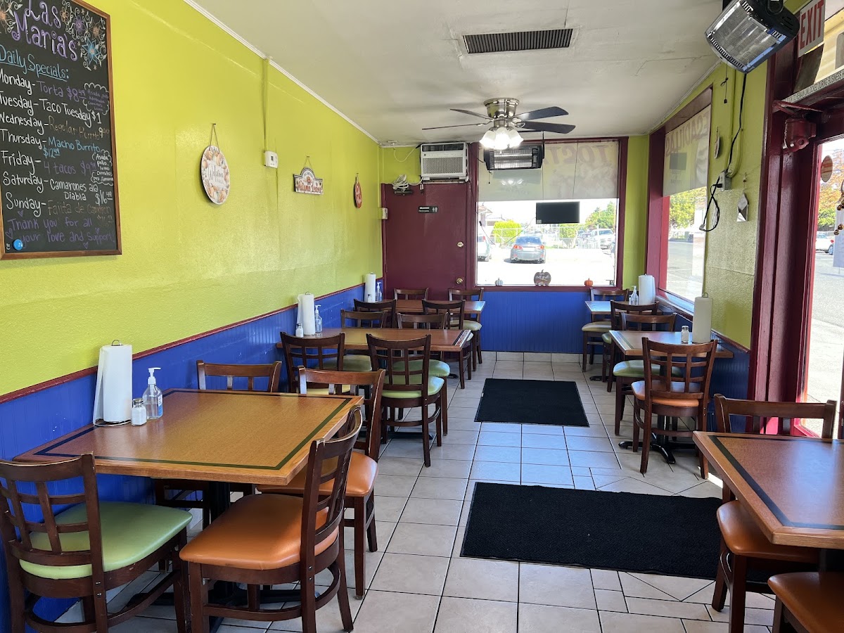 The bright green and blue dining room of Taqueria Las Maria's with the daily specials chalkboard